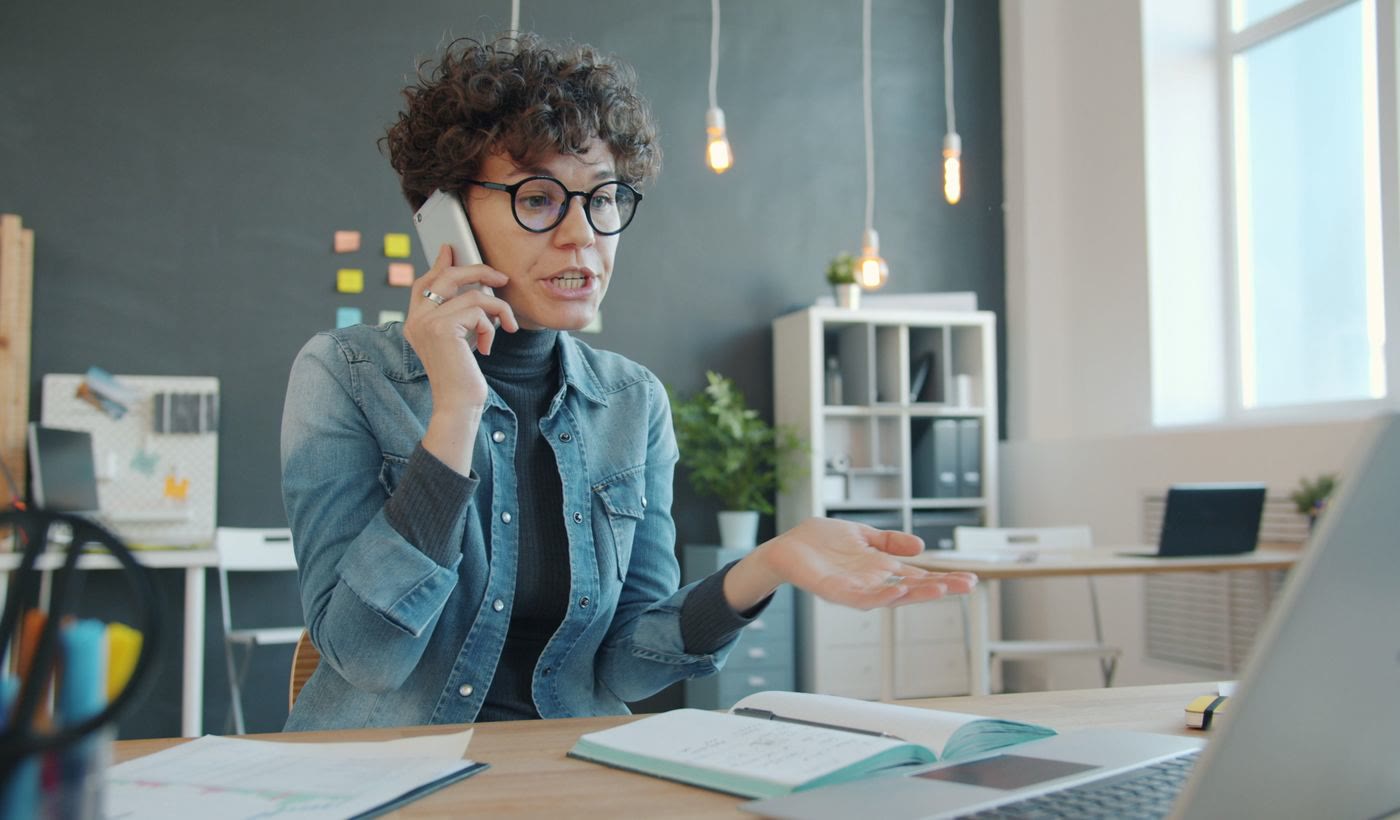 A woman explaining a point on a phone call with her hand open
