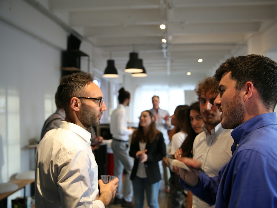 People talking in small groups at a networking event