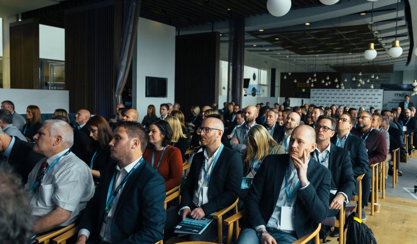 Rows of people listening to a talk at a business conference