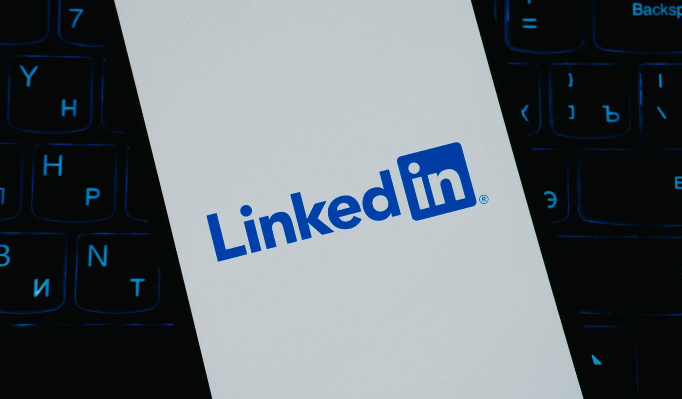 The LinkedIn logo on a smartphone screen lying on a keyboard